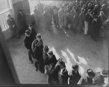 Unemployment benefits aid begins. Line of men inside a State Employment Service office at San Francisco, Calif., waiting to register for benefits on one of the first days after the office opened in Jan. 1938.These workers will receive dfrom $6 to $15 per week for as long as 16 weeks. Twenty-two states begin paying unemployment compensation as national unemployment reached 10 million, 19% of the workforce. Photo: Lange, Dorothea,/Library of Congress
