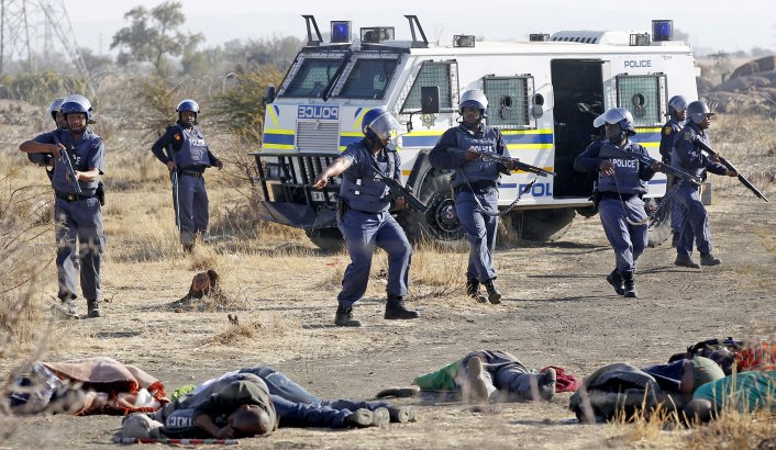 Police approach fallen bodies at Marikuna platinum mine in South Africa on 16 August 2012