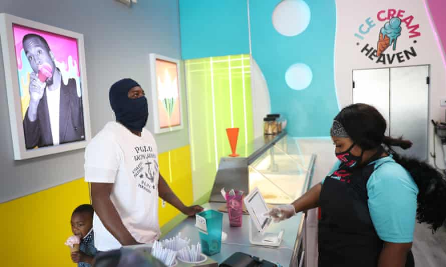 Charles Hood and his son Charistan buy ice cream from business owner Tiffany Miller at Ice Cream Heaven in Miami Gardens, Florida. 